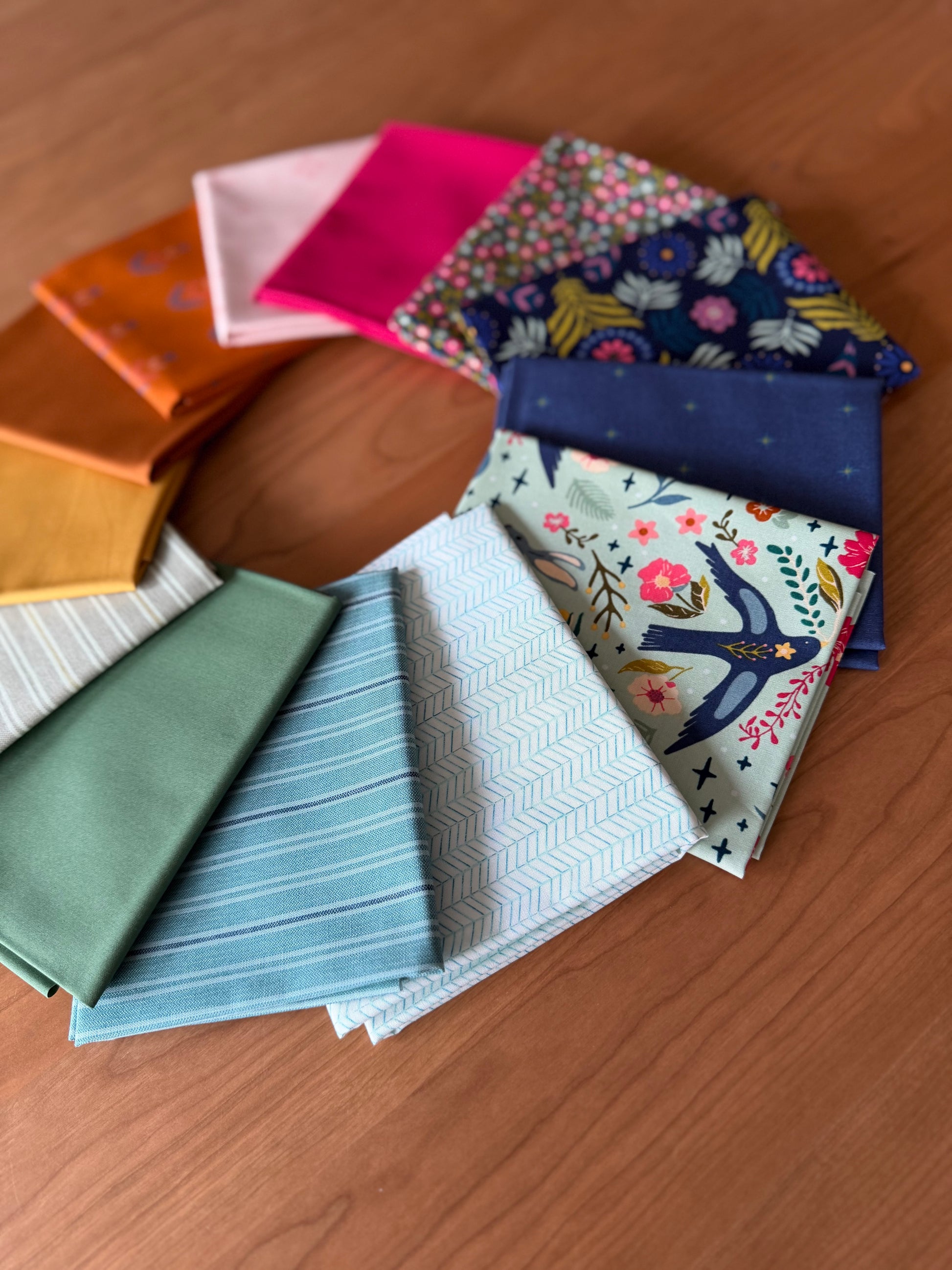 Collection of colorful fabric swatches on a wooden surface