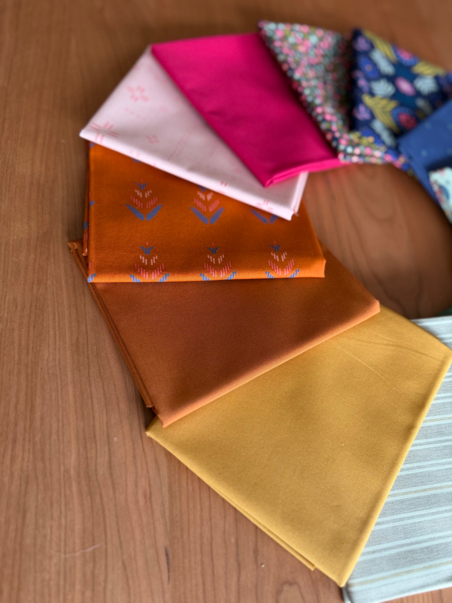 Collection of colorful fabric samples on a wooden surface