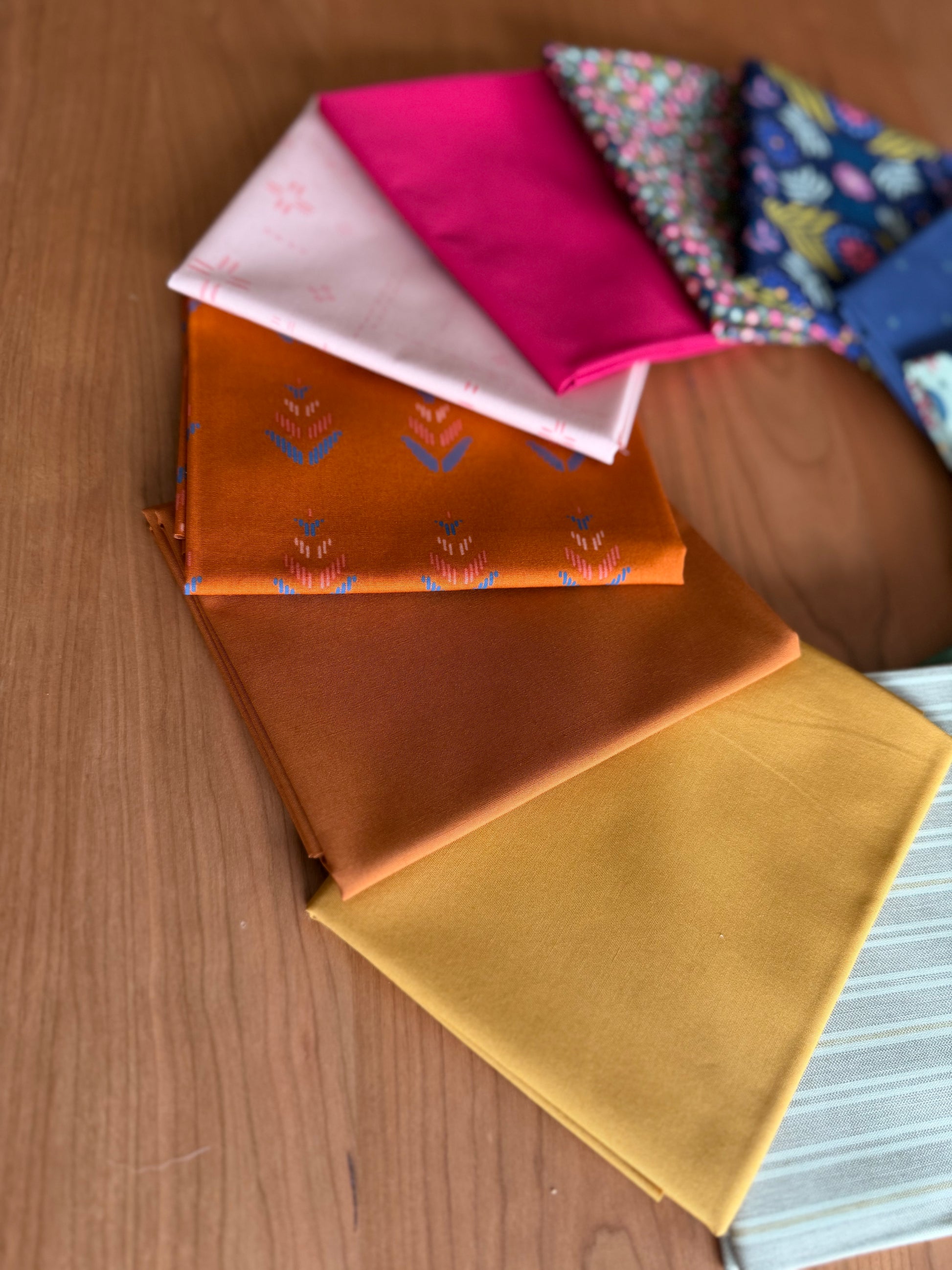 Collection of colorful fabric samples on a wooden surface