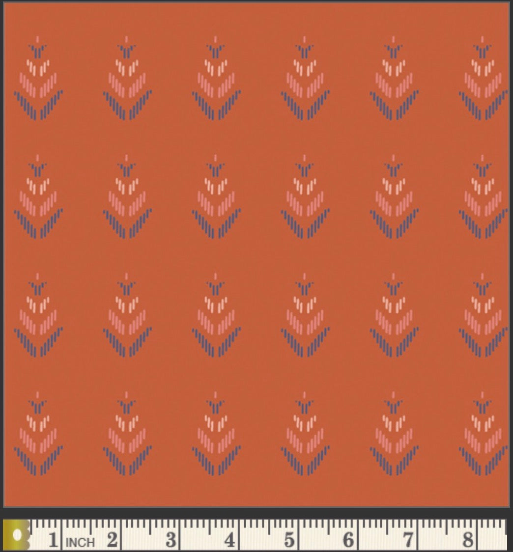 Patterned fabric with a ruler at the bottom for scale on an orange background