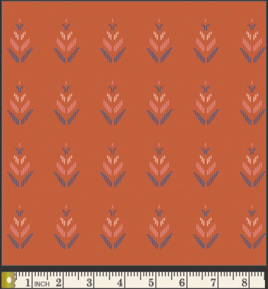 Patterned fabric with a ruler at the bottom for scale on an orange background
