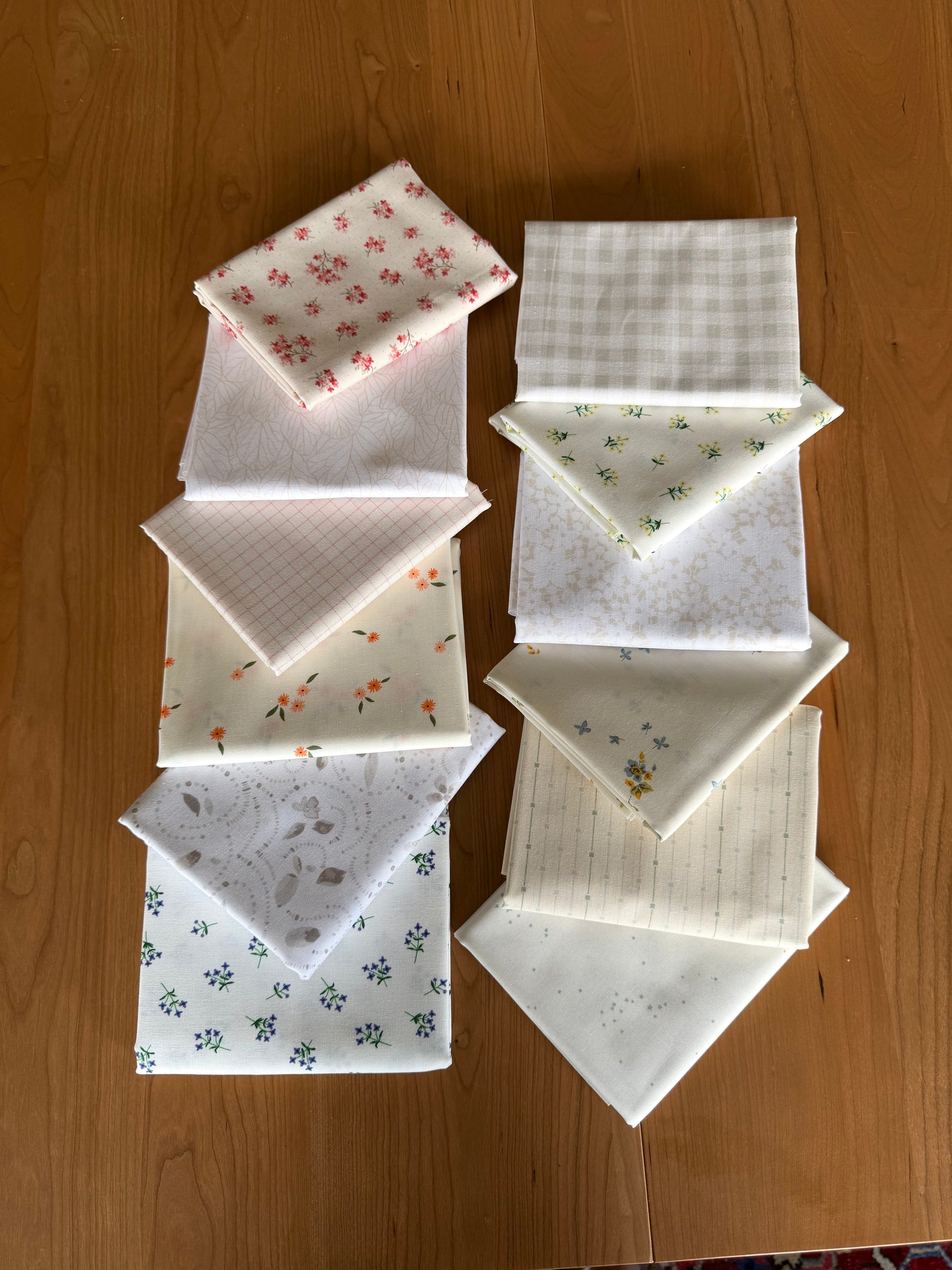 Set of low volume  fabric squares with various patterns on a wooden surface